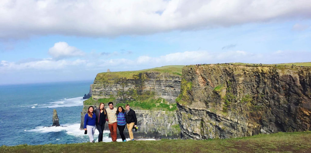 Five students on edge of sea cliff.