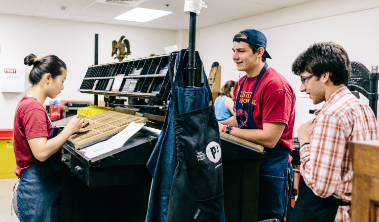 Students work at printer press.